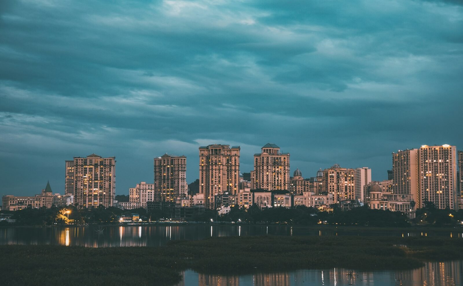 lighted city buildings near body of water